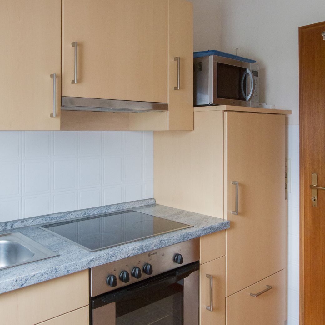 Küchenzeile mit Kuhlschrank, Herd, Ofen und Mikrowelle