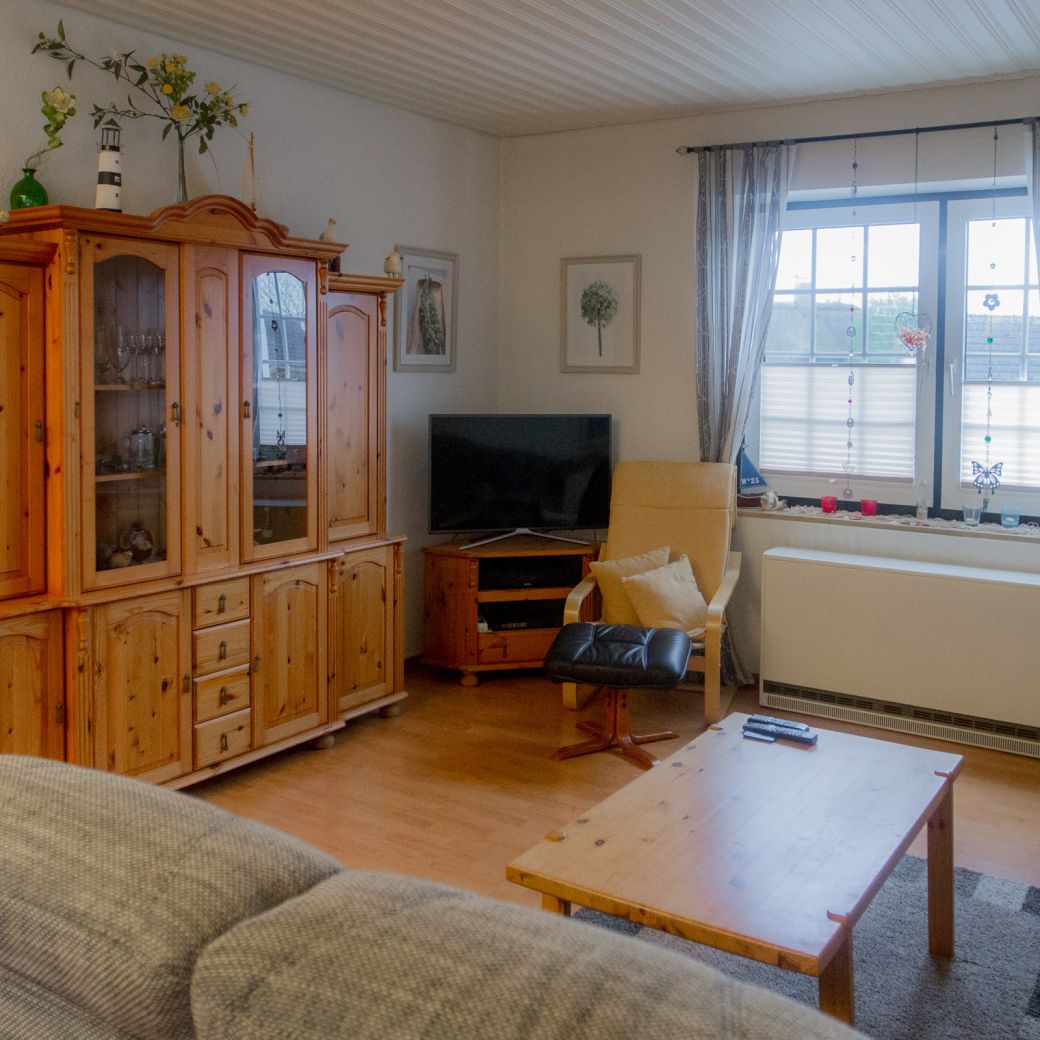 Wohnbereich mit großer Couch, Sessel & TV